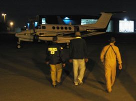three men walking toward plane