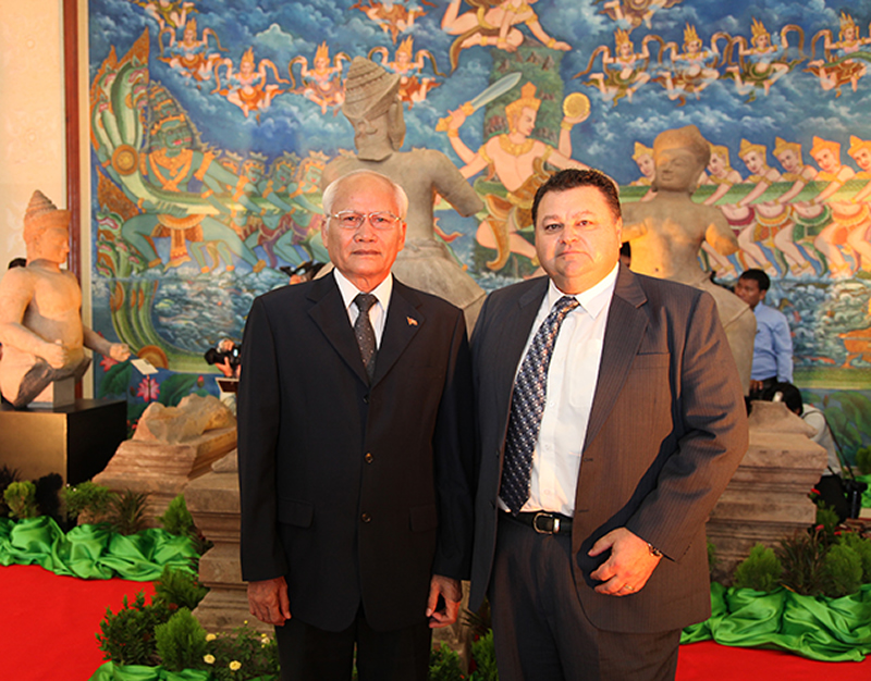 photo of HSI Phnom Penh Attaché JP Galoski with His Excellency, Chuch Phoeun, Secretary of State for the Ministry of Culture posing in front of the statues prior to commencement of the ceremony
