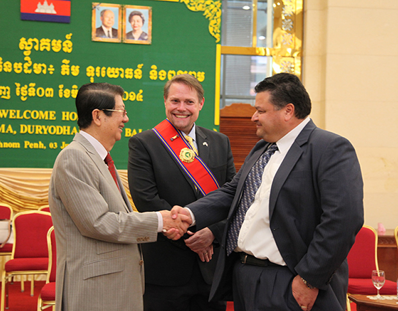 photo of HSI Phnom Penh Attaché JP Galoski shaking the hand of Deputy PM Sok An with DCM Jeff Daigle looking on at the conclusion of the ceremony