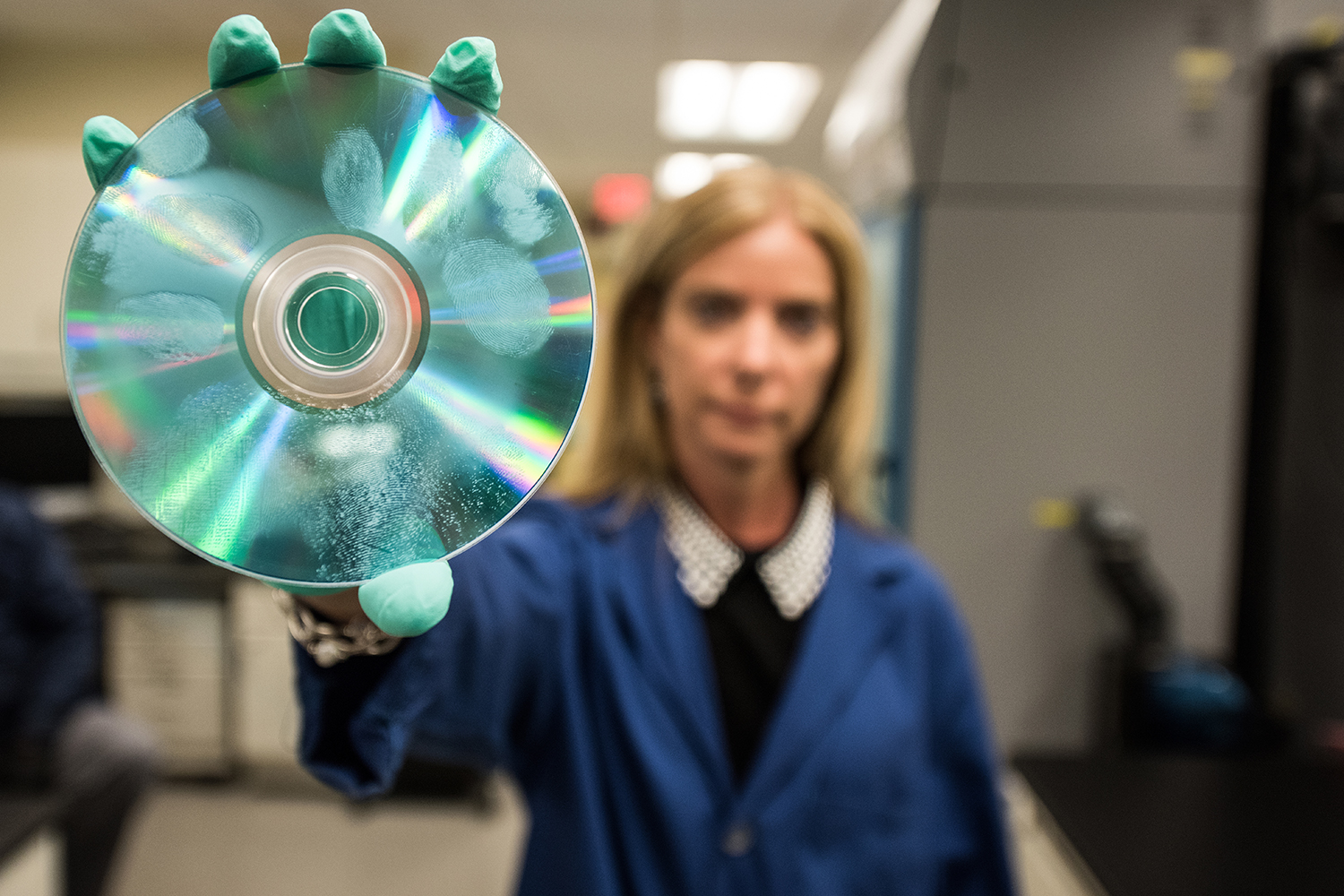 agent holding a CD with fingerprints on it