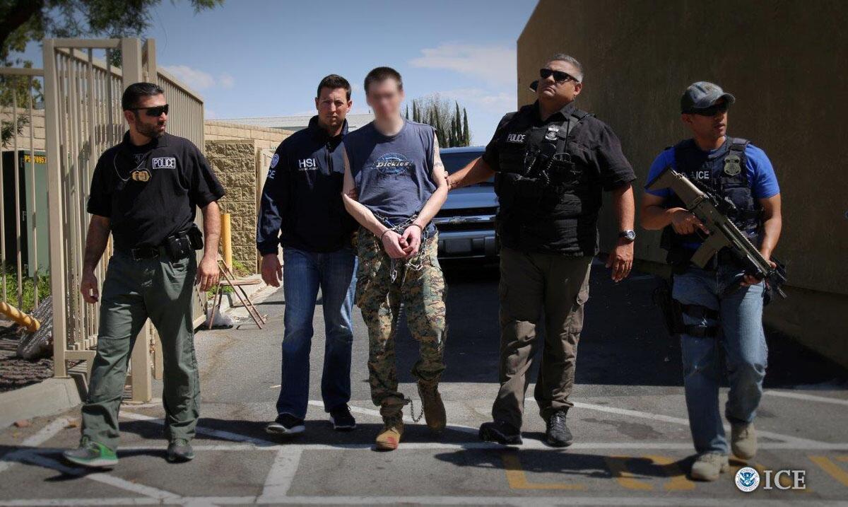 Officers arresting an individual with their face blurred out