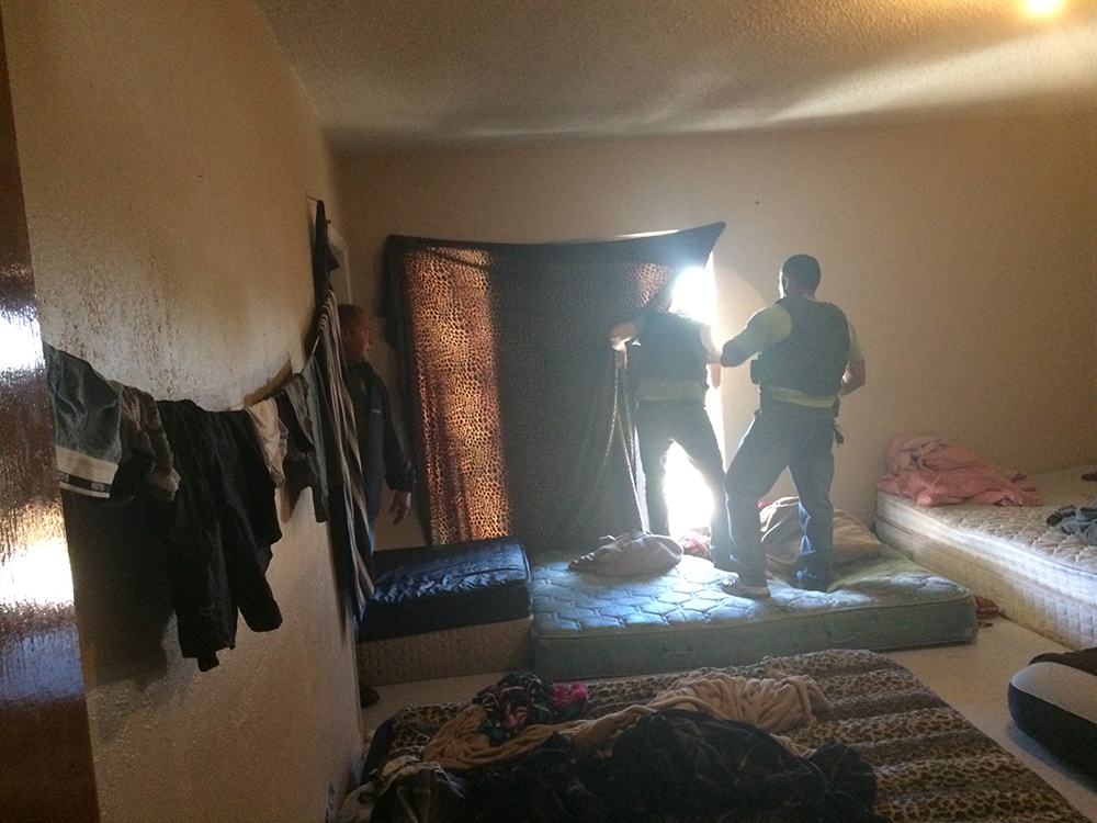 Oficiales de Equipos de Trabajo de ICE HSI realizan registro en habitaciones vacías en una residencia escondite en la frontera suroeste.