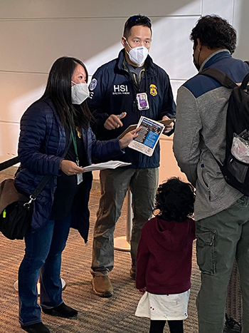 Two ICE special agents performing outreach at Dulles airport