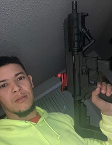 Enil Mejia-Zuniga posing with high-powered weapons and financial gains