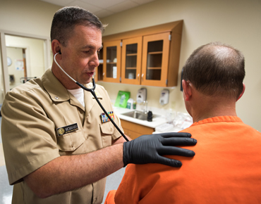Personal del Cuerpo de Servicios de Salud (IHSC) de ICE evaluando a un paciente