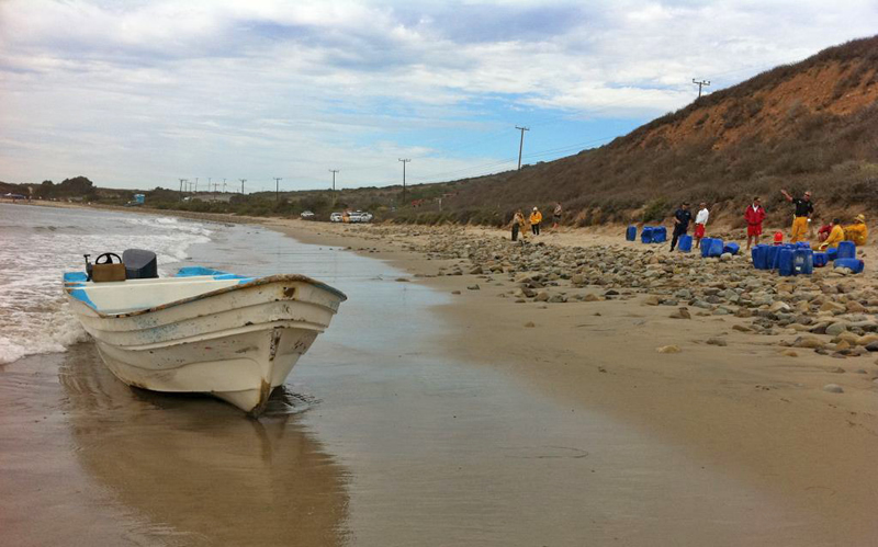 Small, 30-foot fishing boats try to make their way to shore along the California coast.