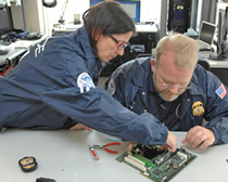 HSI special agents gather data off a computer at the new forensic lab in Boston