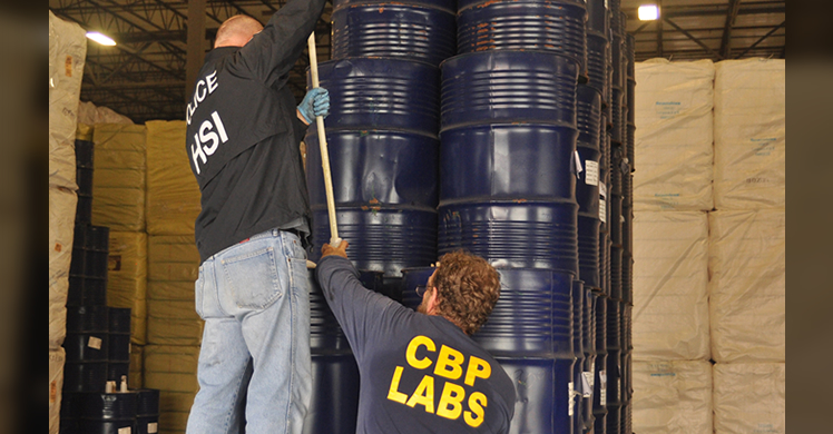 HSI special agent and CBP officer inspecting seized honey.