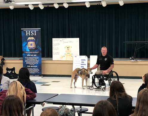 HSI Tampa Computer Forensic Analyst Justin Gaertner and his service dog Gunner presented to Tampa Bay area children during the Great American Teach-In