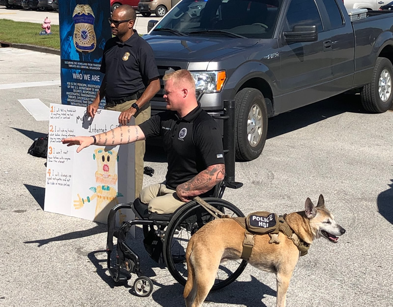 HSI Tampa Special Agent Alvis Lockhart and Computer Forensic Analyst Justin Gaertner and his service dog Gunner presented to Tampa Bay area children during the Great AmericanTeach-In