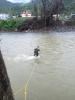 A special agent with HSI New York's SRT wades through a river to reach Juana Dias, PR. Even with the bridge out, the team crossed to meet the helicopter that was landing with food and water on the other side.